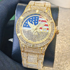 A gold-toned luxury quartz wristwatch featuring a patriotic design with stars and stripes on the face.