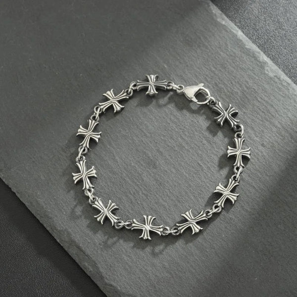 Silver metal bracelet featuring a pattern of small cross charms