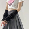 A person wearing a white t-shirt and gray pleated skirt is shown holding black fingerless arm warmers.