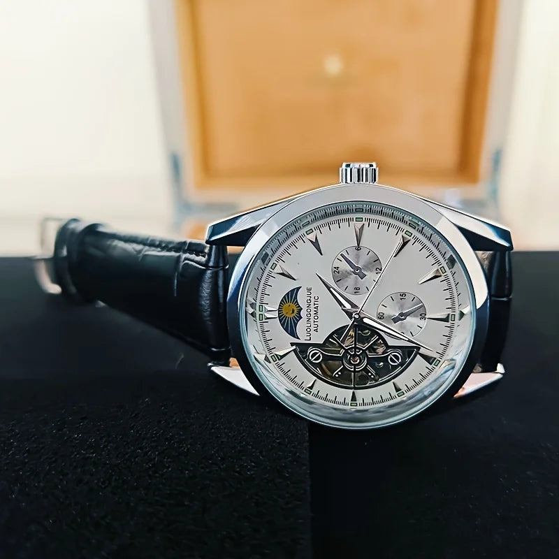 A silver luxury automatic mechanical men's wristwatch with a black leather strap displayed on a dark surface.