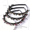 Boucles d'oreilles en perles noires et roses présentées sur une surface blanche.