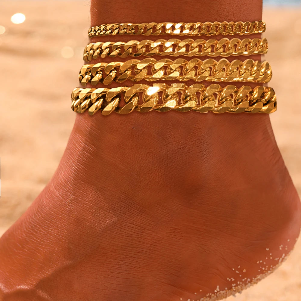 Gold multi-chain stainless steel anklets stacked on a person's foot.