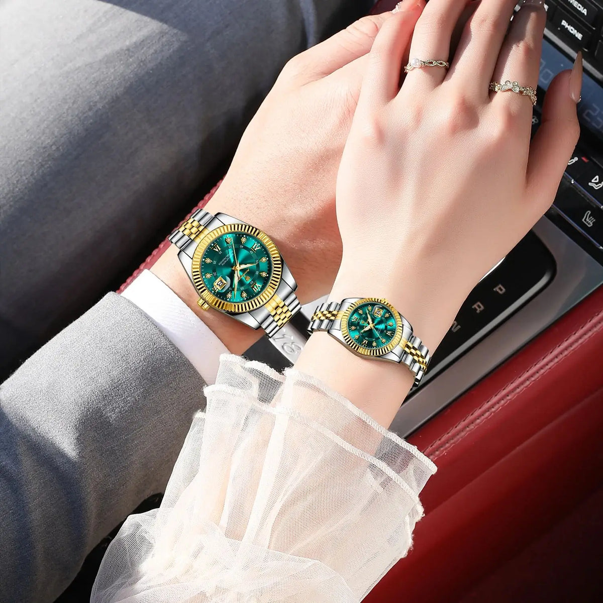 A close-up of a hand wearing a gold and silver watch with a green face and a matching bracelet, resting on a red surface.