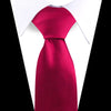 A vibrant magenta silk necktie worn under a white dress shirt collar.