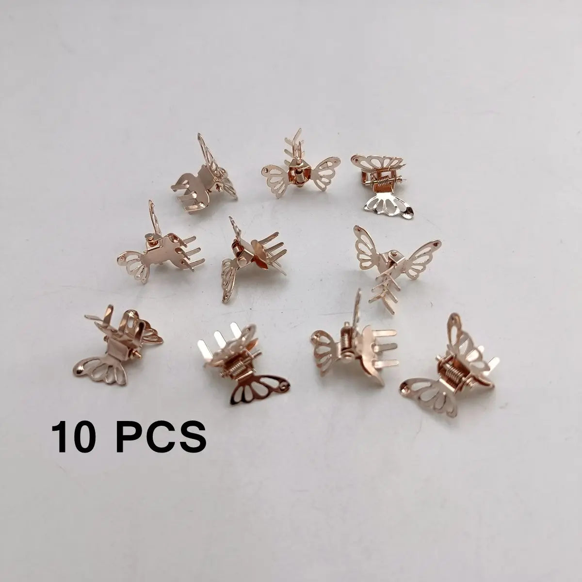 A set of ten mini hollow butterfly metal hair clips in silver tone arranged on a white background.