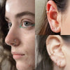 Nahaufnahme eines Gesichts und Ohrs mit verschiedenen chirurgischen Nasen-Hakenohrringe und Ohrpiercings.