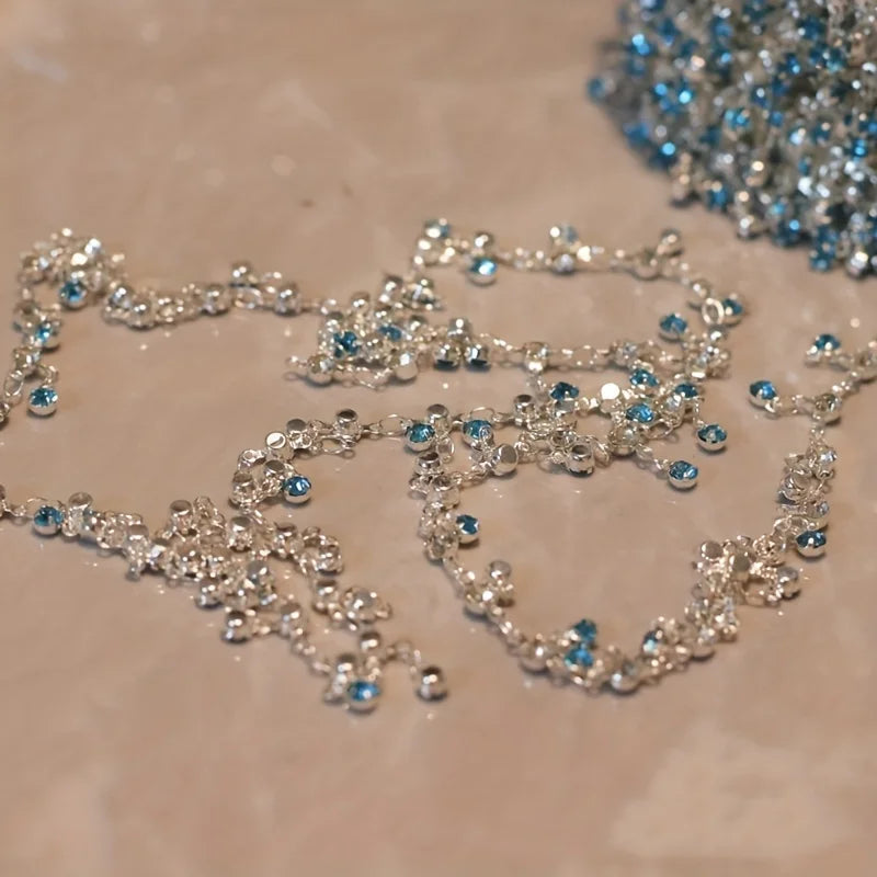 Silver stainless steel anklets featuring blue rhinestone pendants and chains.