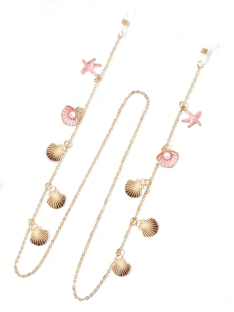 Chaîne délicate en métal doré avec des charms étoiles de mer et coquillages pour lunettes.