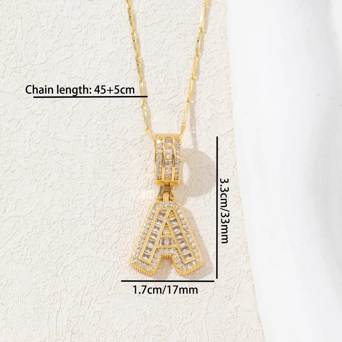 Gold initial letter necklace featuring a CZ crystal pendant, displayed against a light background.