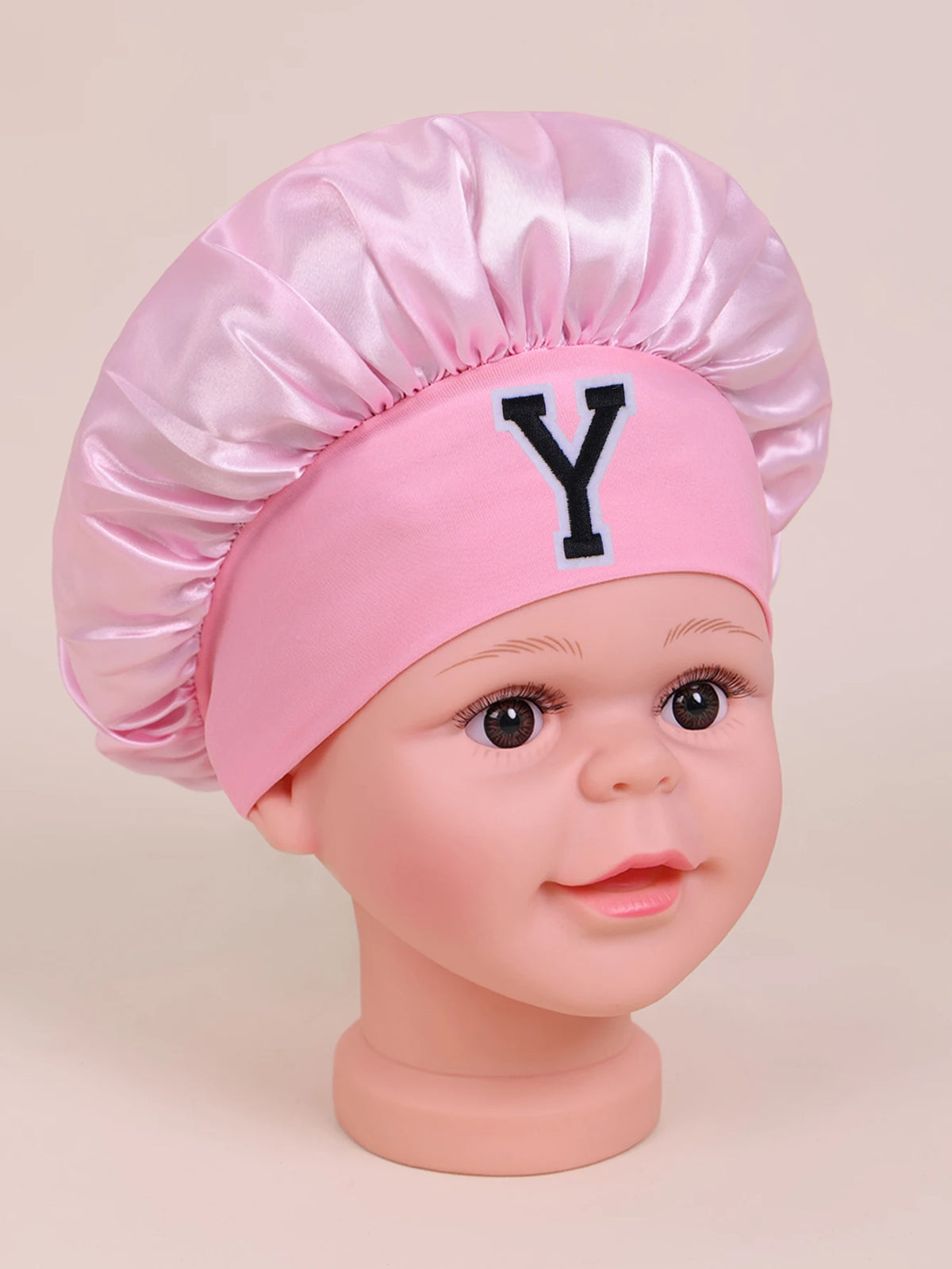 Pink sleep cap for kids with a large black letter Y embroidered on the front