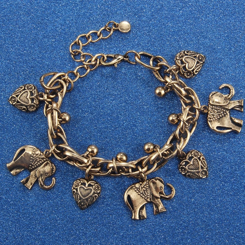 Vintage gold elephant charm bracelet featuring a chain and various animal motifs.