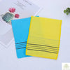 A set of two bright blue and yellow exfoliating bath washcloths are displayed next to a piece of paper.