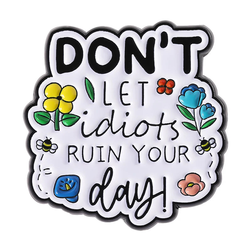 Black and white enamel pin featuring the text DON'T LET IDIOTS RUIN YOUR DAY!