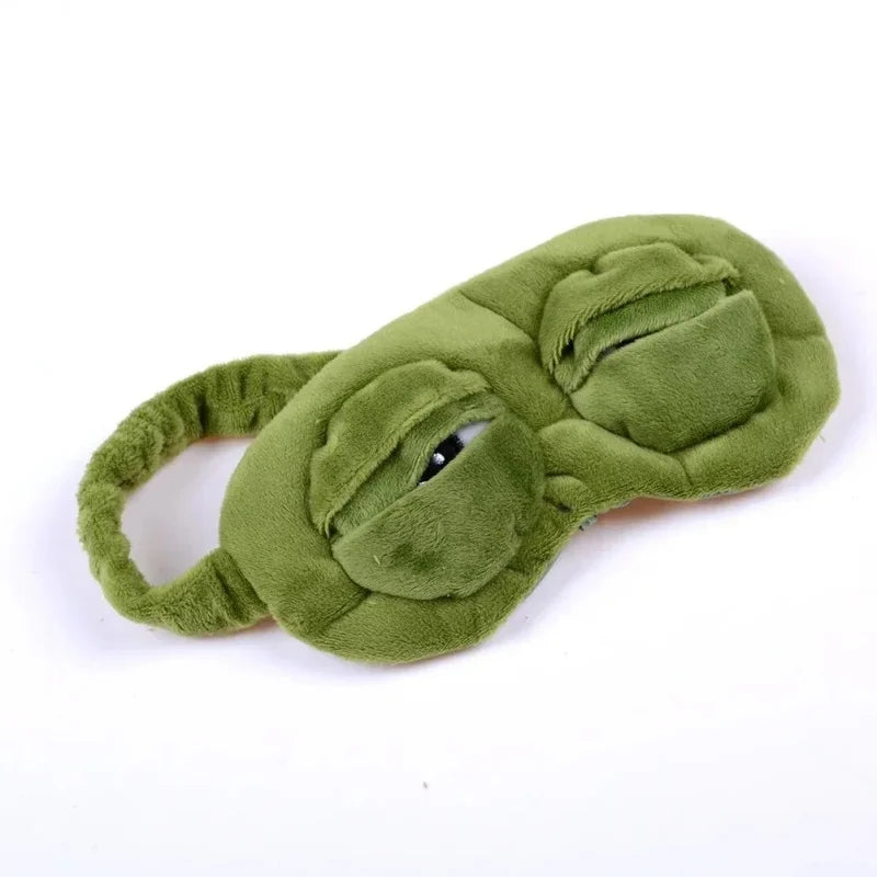 A soft green cotton sleep mask shaped like an animal, shown from above.