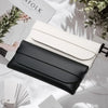 A black leather eyeglass case is shown open next to a white case on a light surface.