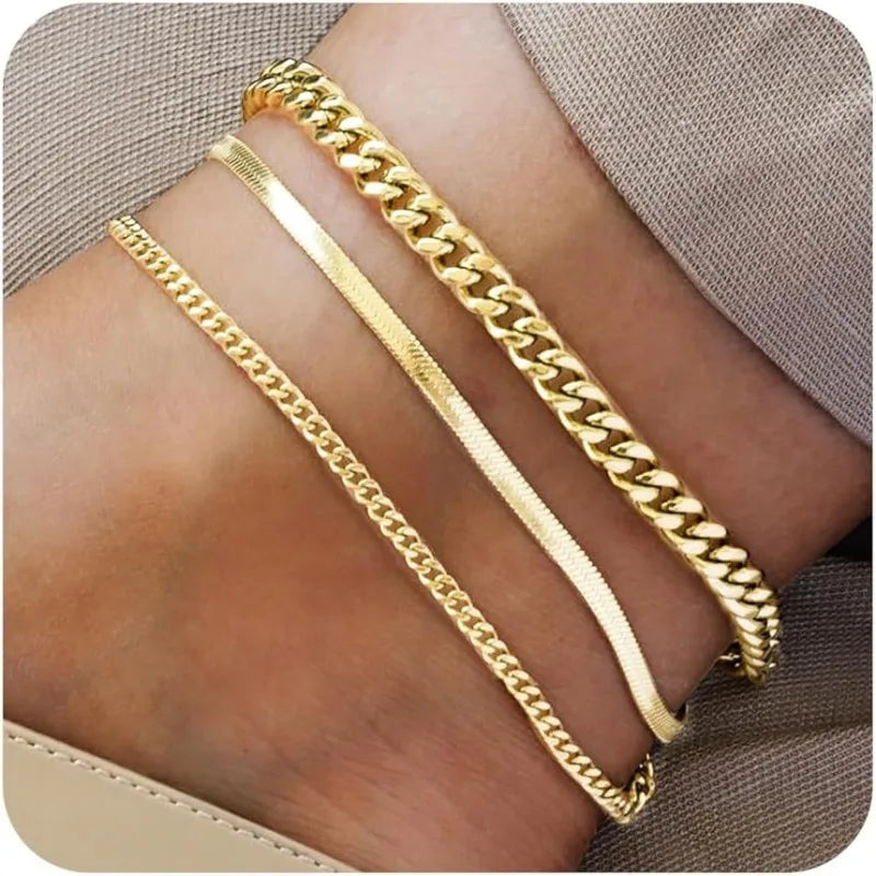 Drei Stränge aus 14K vergoldetem Edelstahl-Armbänder, getragen am Knöchel.
