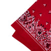 A close-up of a red bandana scarf featuring intricate white and black geometric patterns.