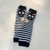 Black and white striped fingerless socks featuring skull and flower designs