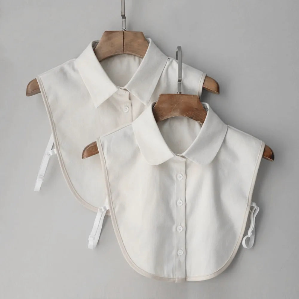 A white elegant detachable button-up collar shirt is displayed on a wooden hanger against a light gray background.