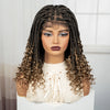 A woman modeling a long, dark brown boho box braid wig with dramatic eye makeup and a cream-colored sweater.