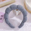 A gray cloud sponge headband is shown against a white background with a wooden tray and pink box.