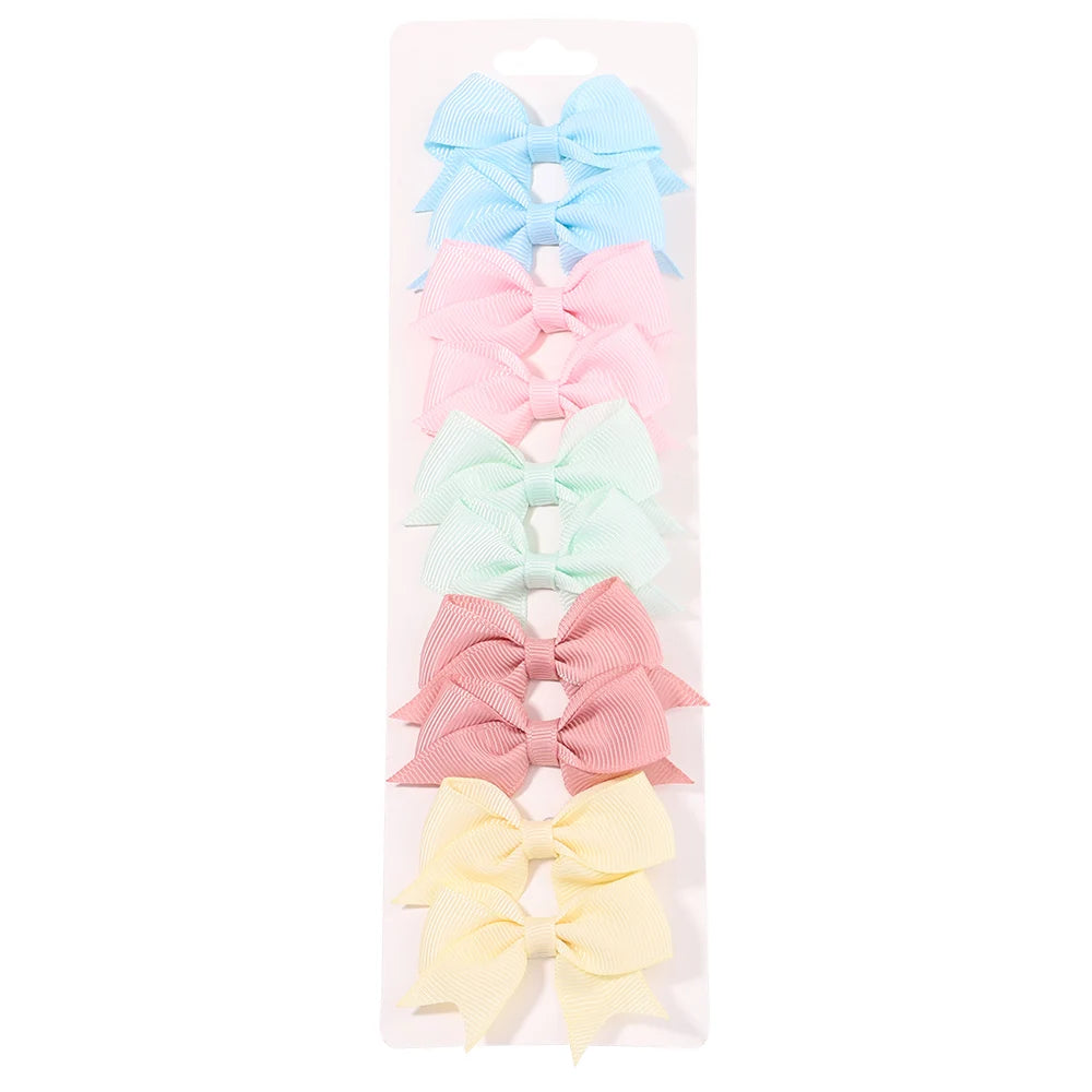 Un juego de clips para el pelo de niños de colores sólidos en azul claro, rosa, verde menta y melocotón.