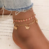 Goldenes Vintage-Schmetterlingsherz-Armbandset, getragen am Knöchel.