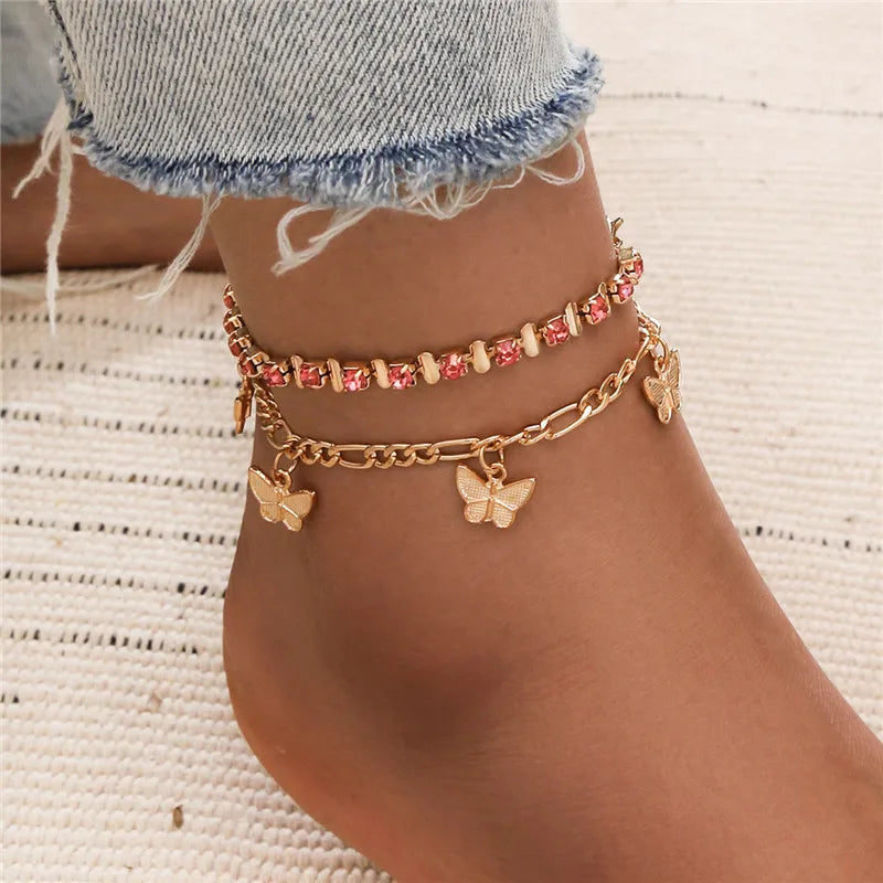 Goldenes Vintage-Schmetterlingsherz-Armbandset, getragen am Knöchel.