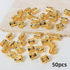 A set of 50 gold-colored, textured metal hair rings and clips scattered on a light surface.