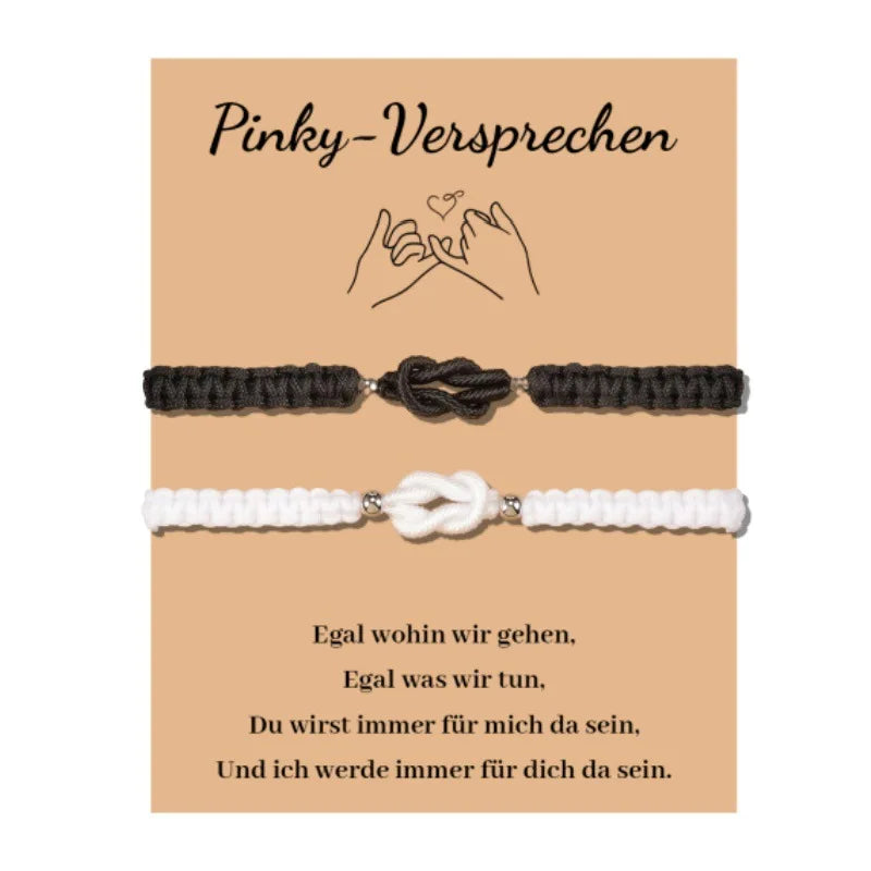 A pair of dark gray knitted pinky promise bracelets for couples with a heart knot design.
