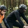 A man wearing a black long-sleeved shirt and helmet is outdoors in a forest setting.