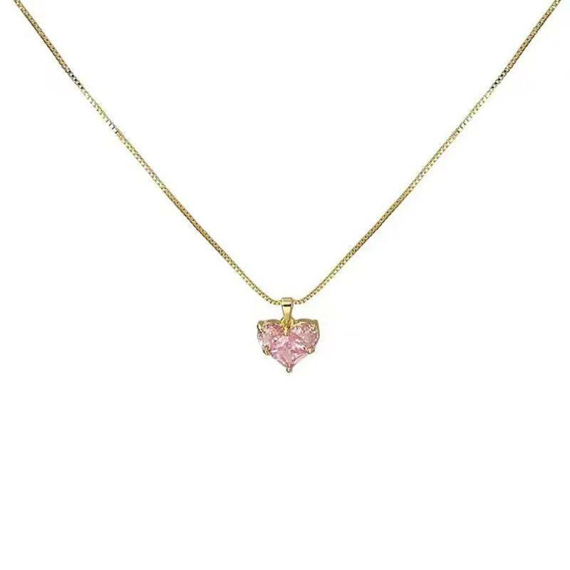 A delicate gold chain necklace featuring a pink crystal heart pendant.