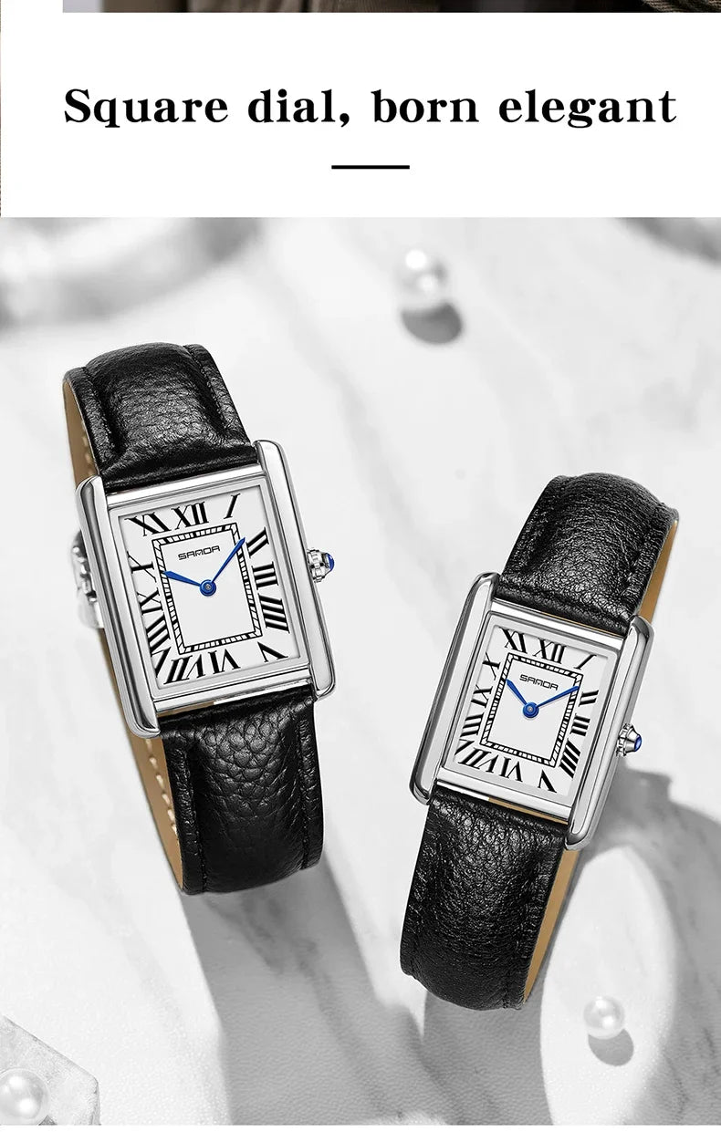 Nahaufnahme einer silbernen, quadratischen Armbanduhr mit schwarzem Lederband auf einer hellen Oberfläche.