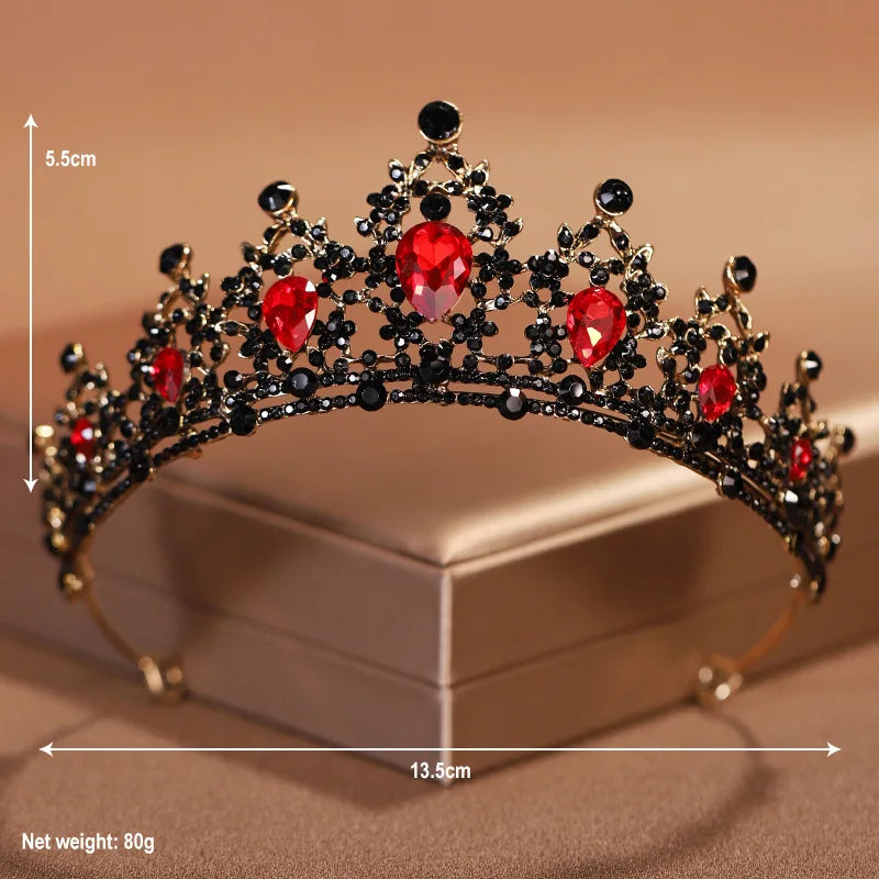 A gold-toned crystal baroque bridal tiara headpiece with red stones displayed on a box.