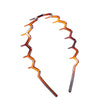 An orange zigzag headband hair comb used for face concealment.