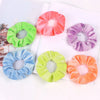 A set of six velvet scrunchies in various shades including pink, purple, green, and orange, displayed on a white background.