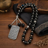 A black beaded necklace with a silver pendant featuring Arabic calligraphy of Ayatul Kursi