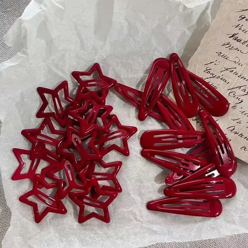 A set of red star snap clips for hair and barrettes displayed on white paper.