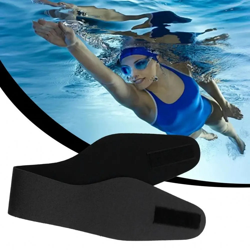 Black adjustable swimming headband floating underwater with a person swimming above
