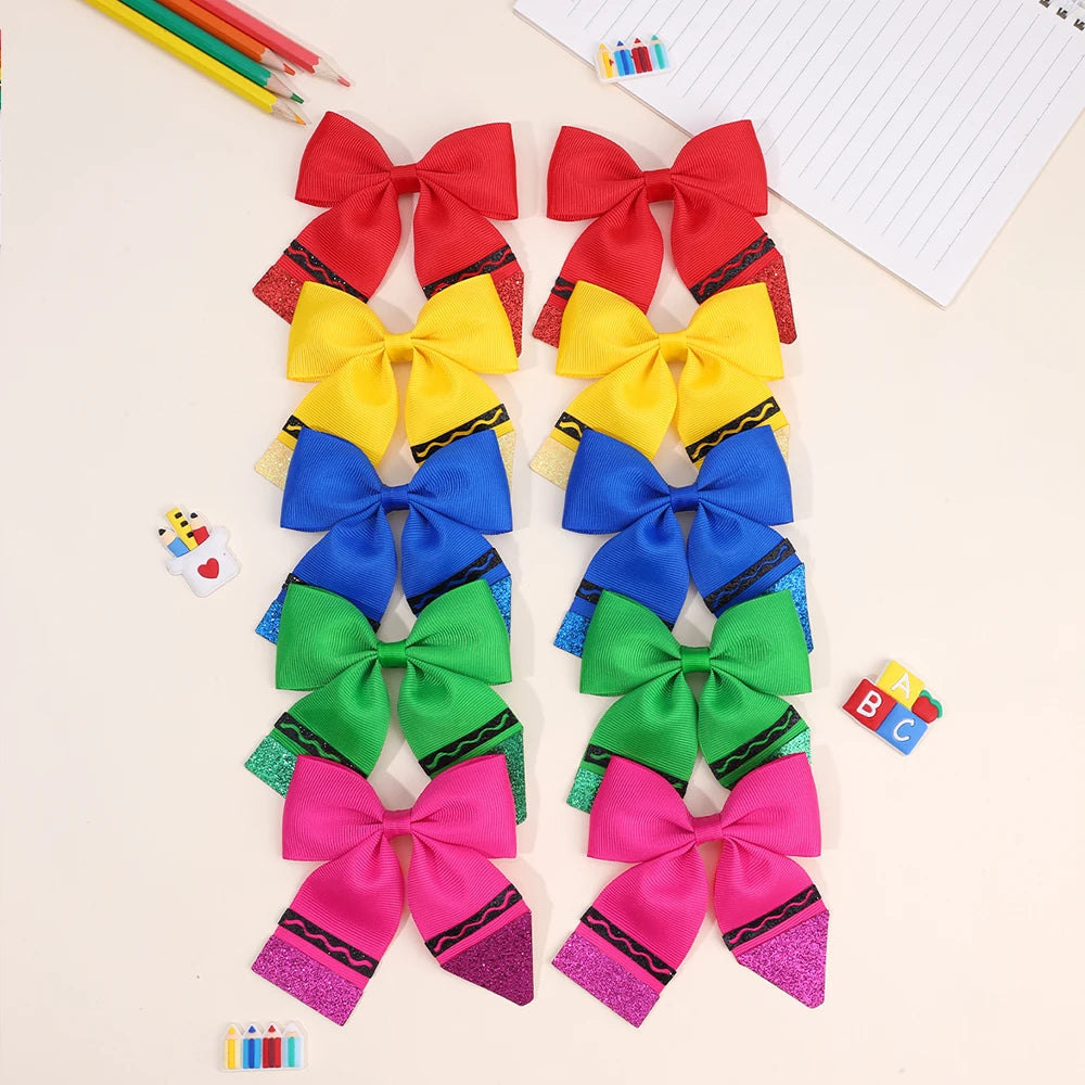 A set of colorful pencil bow hair clips featuring red, yellow, blue, green, and pink fabric bows.