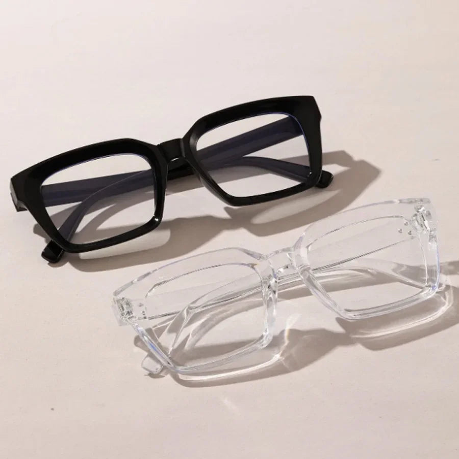 A pair of black-framed reading glasses and a pair of clear plastic reading glasses are displayed on a white surface.