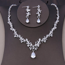 A silver-toned bridal headwear set featuring a necklace and matching earrings with clear stones.