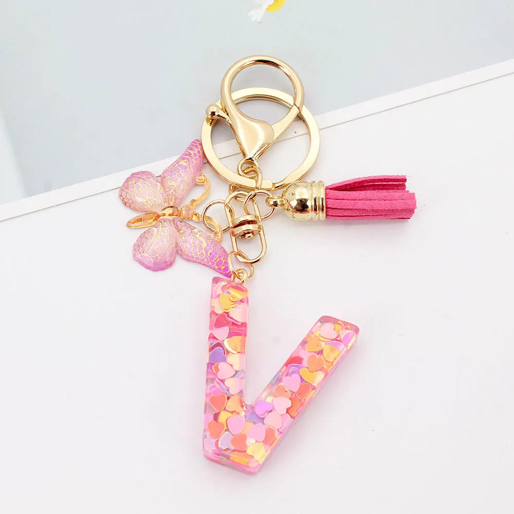 Alphabet letter L acrylic keychain with a pink butterfly charm and a pink tassel