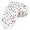 Une pile de nœuds papillons en coton à imprimés floraux élégants, avec des fleurs violettes, roses et bleues sur fond blanc.