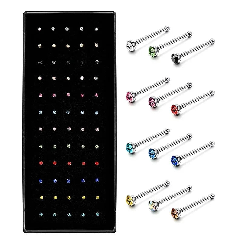A set of stainless steel nose studs and body piercing jewelry in various colors and styles.