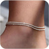 Silver plated beaded anklets worn around the ankle of a person.