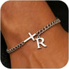 A close-up of a personalized stainless steel cross Cuban chain bracelet worn on a wrist.