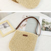 A light beige hand-woven straw visor hat is displayed on a white surface next to a magazine.