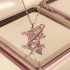 A delicate pink heart necklace featuring zircon stones, displayed in a square box.