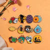 Eine Sammlung von 12 Emaille-Pins mit Charakteren aus der Son Goku Master Roshi Serie auf orangem Hintergrund.